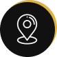 A white location pin icon on a black circular background with a gold ring.