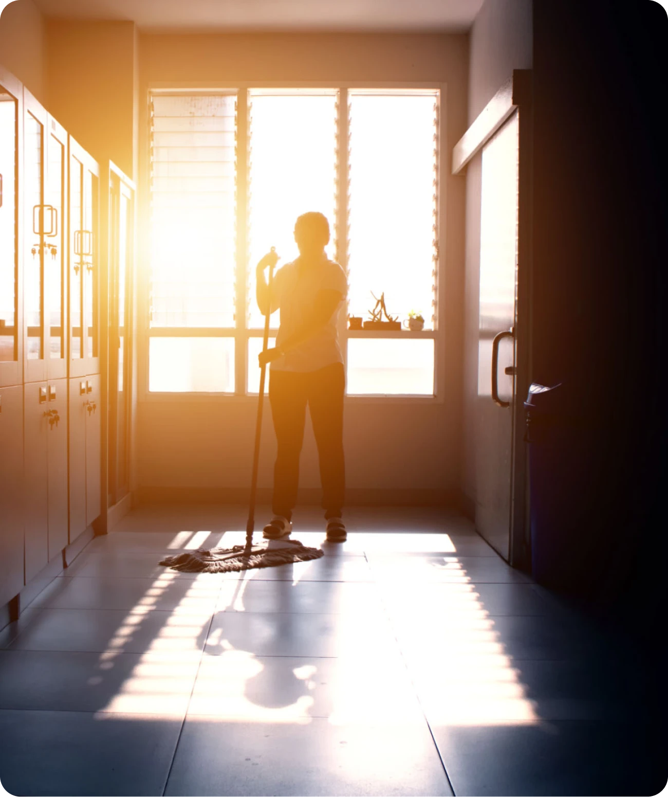 Silhouette of cleaner in sunlit room