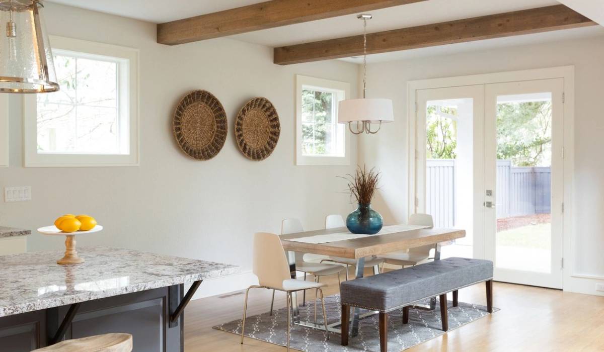 Bright dining area with a wooden table, chairs, and decorative wall baskets.